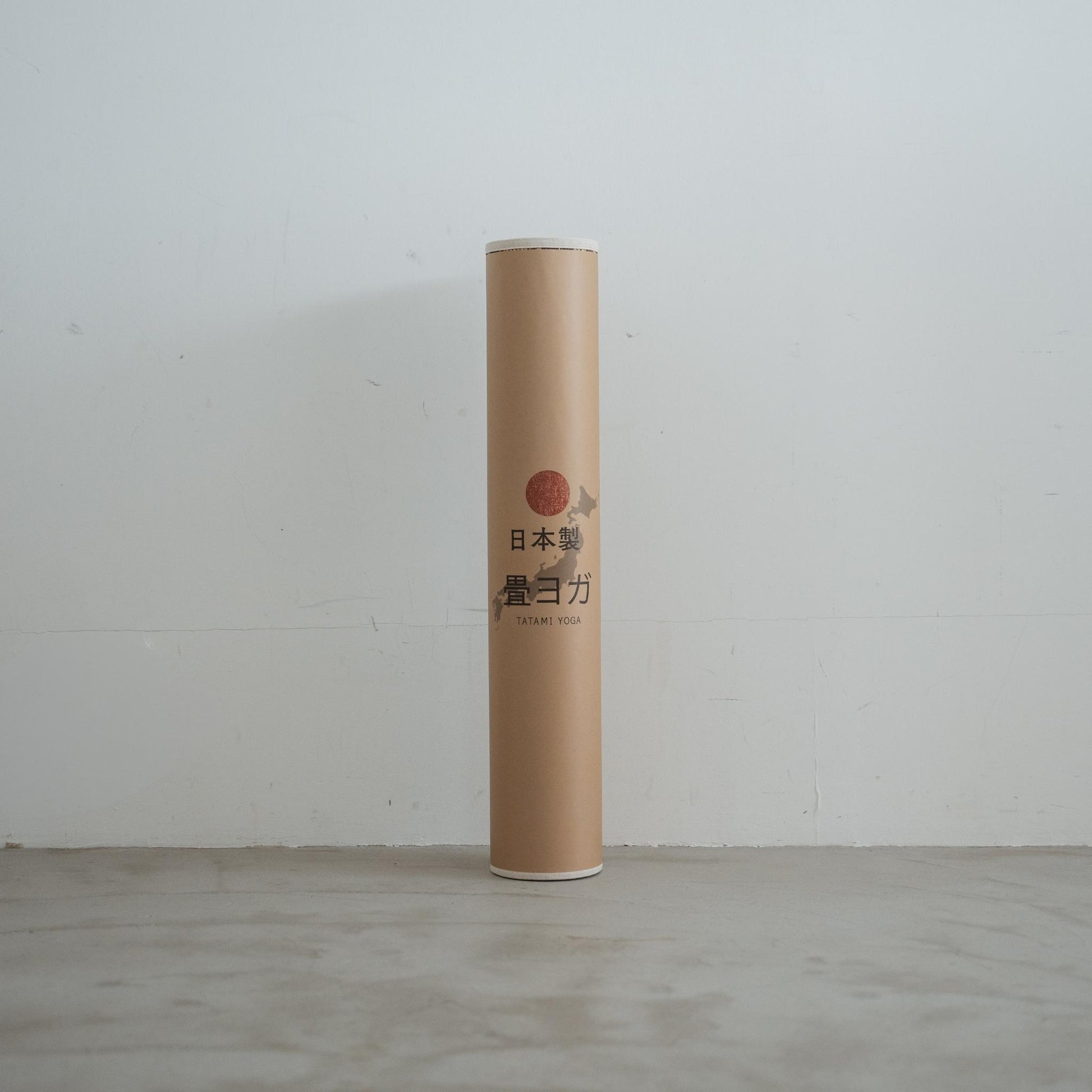 Rolled brown tatami mat standing upright featuring a paper label and natural texture for stylish japanese decor.