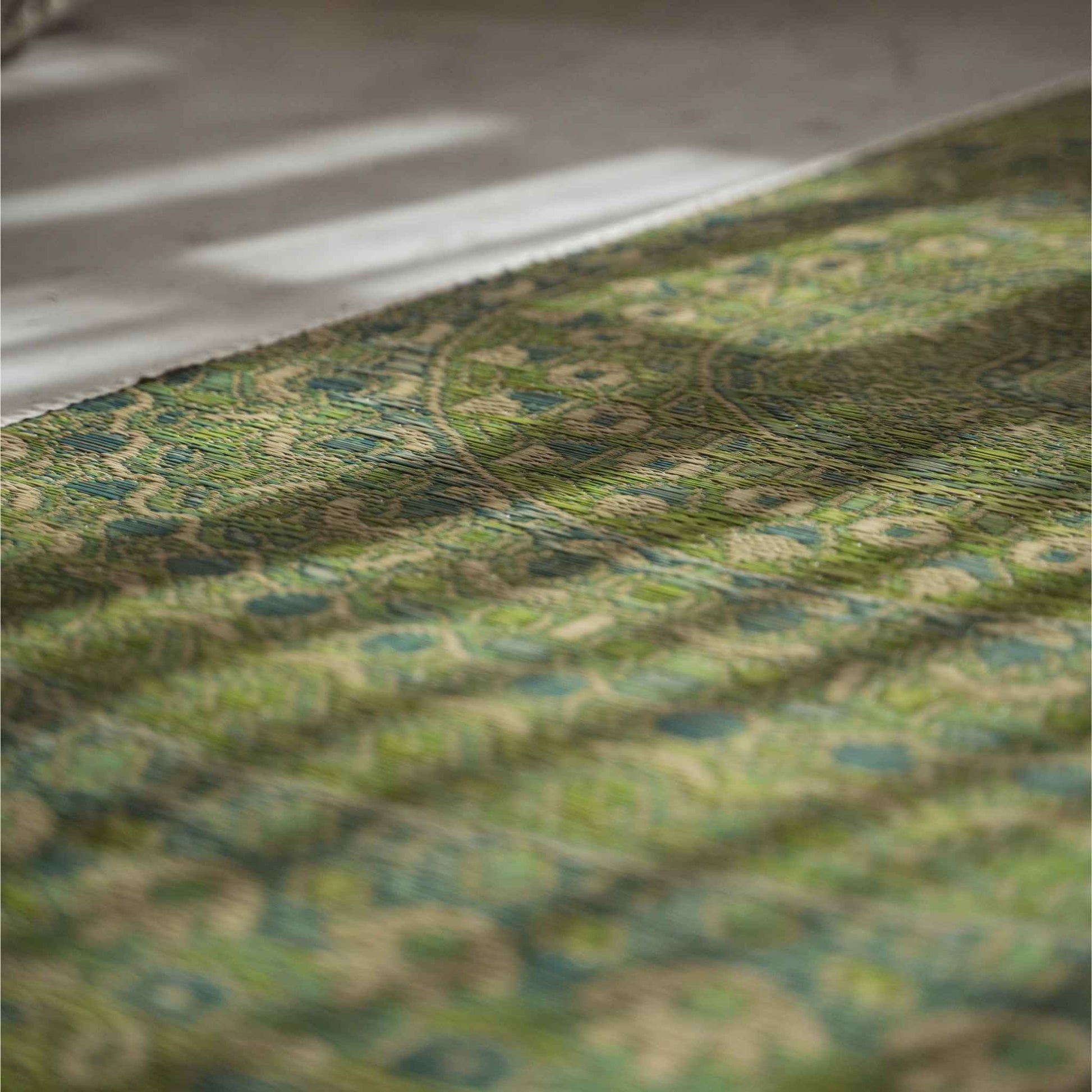 Close up of the green mandala design woven into a rush grass tatami mat for zen decor.