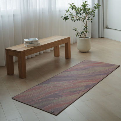 Japanese Tatami Yoga Mattress "Marble" Pink laid on a light wooden floor in a minimalist living room for home meditation.