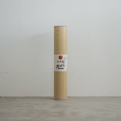 Upright rolled tatami mat displaying a woven green pattern made of rush grass for minimal japanese decor.