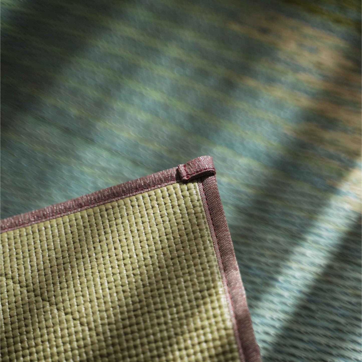 Corner detail of a tatami mat showing the non-slip PVC backing ensuring stability for yoga practice.