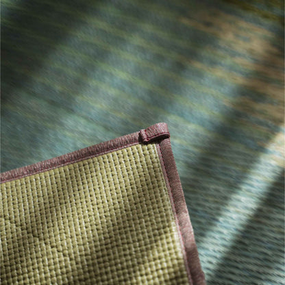 Corner detail of a tatami mat showing the non-slip PVC backing ensuring stability for yoga practice.