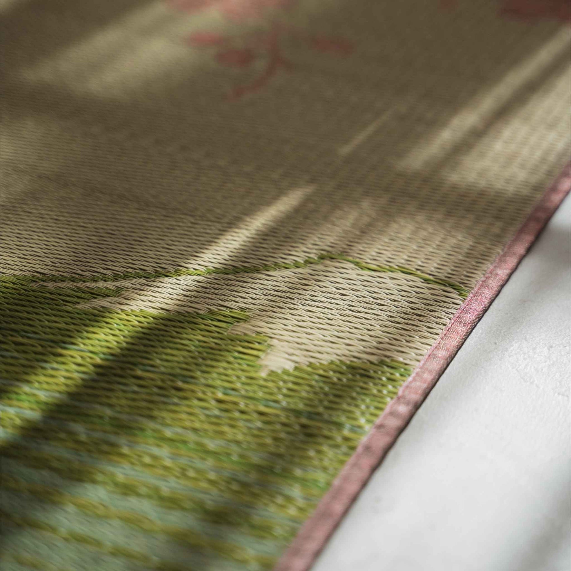 Close up of the rush grass texture on a tatami mat showing the intricate pink sakura weave pattern.