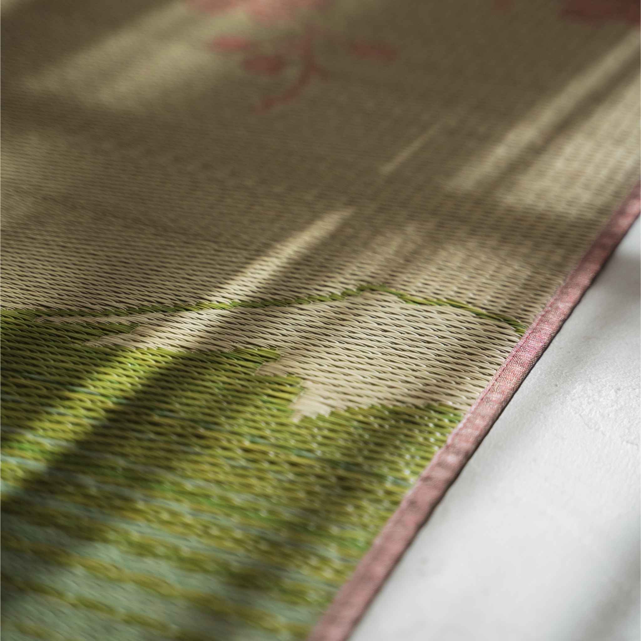Close up of the rush grass texture on a tatami mat showing the intricate pink sakura weave pattern.