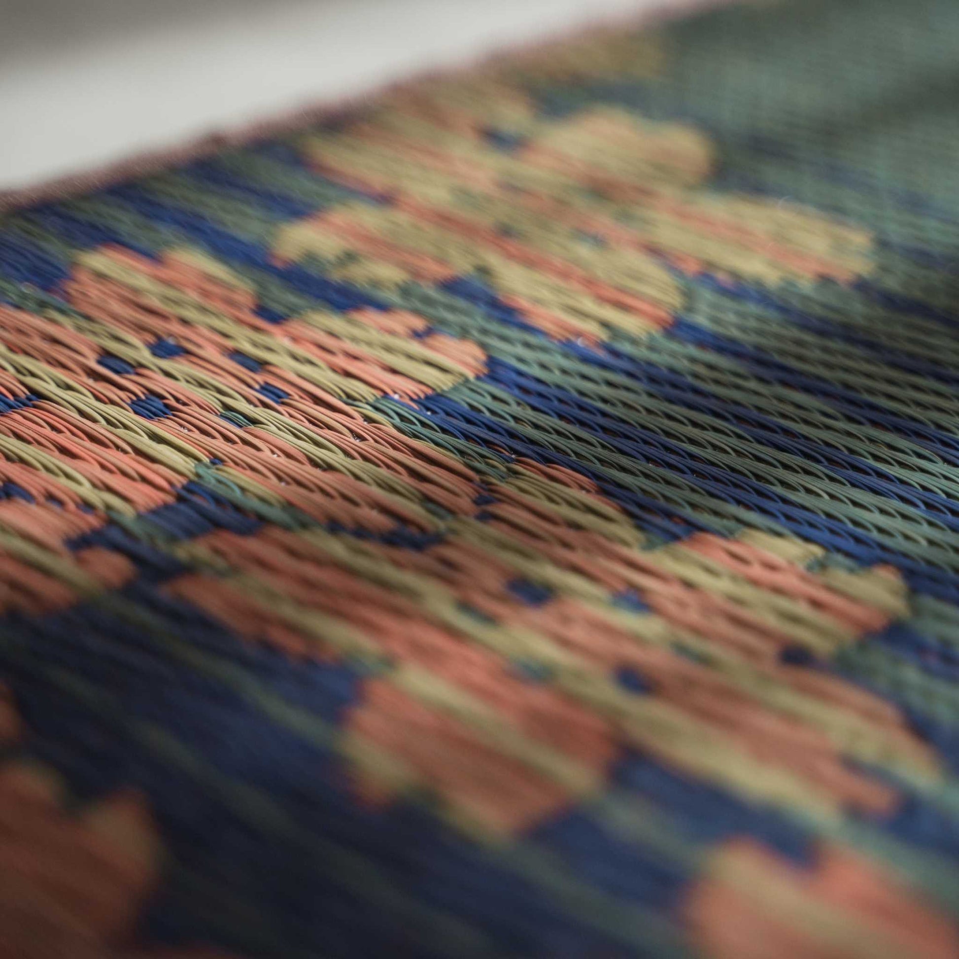 Angled view of a tatami yoga mat featuring a woven cherry blossom design for beautiful Japanese decor.