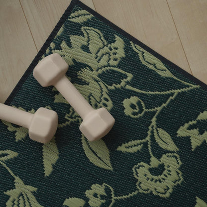 Een bovenaanzicht van de Japanse Tatami Yoga Matras "Sarasa" Navy met een kleine roze halter, die het botanische motief benadrukt.