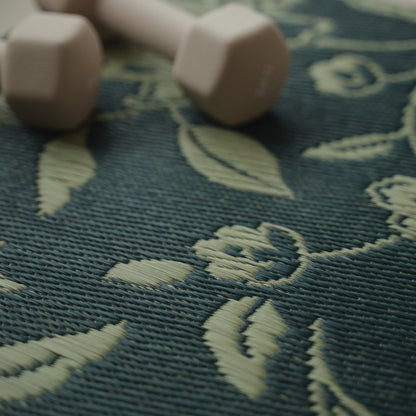 Close-up van het ingewikkelde botanische motief op een Japanse Tatami Yoga Mat "Sarasa" Navy met een halter.