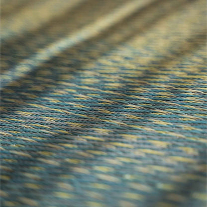 Close up of woven rush grass on a blue tatami mat showing the sky and sea gradient design.
