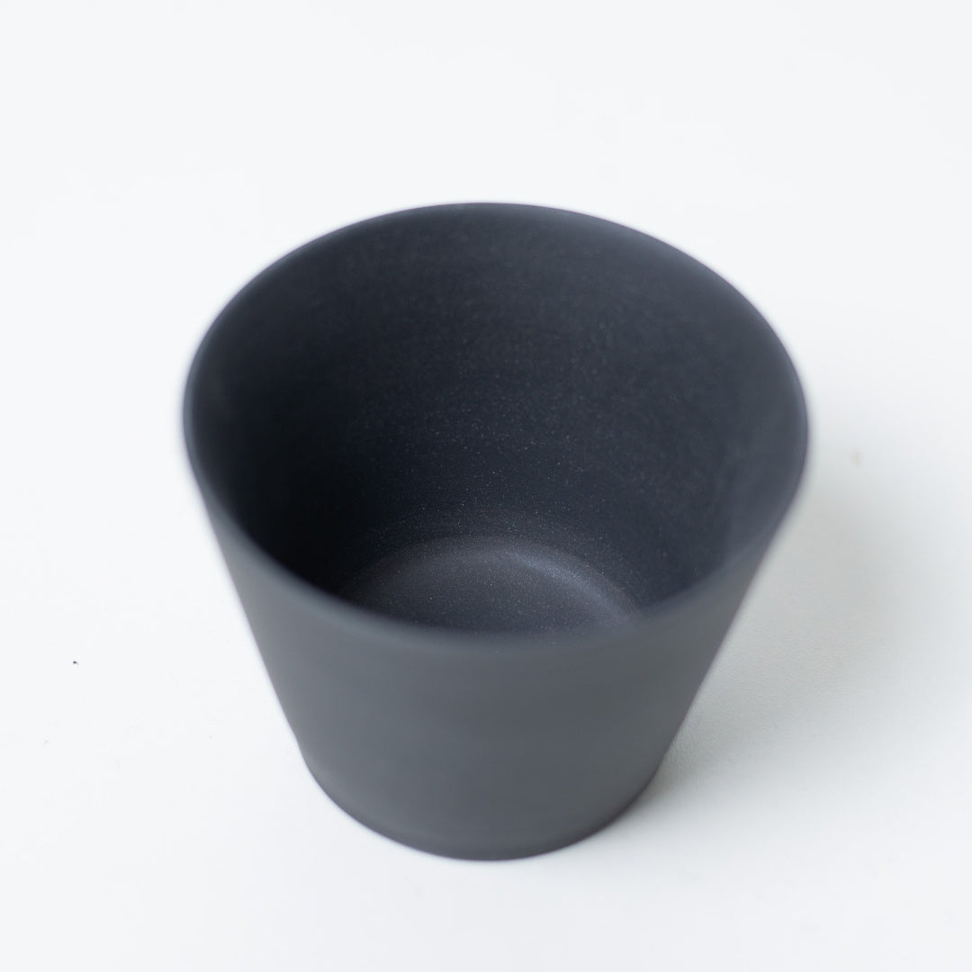 Inside view of an unglazed black japanese tea cup showing the smooth dark clay texture of the ensui chawan