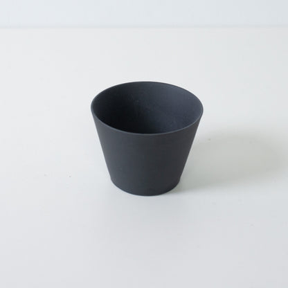 High angle view of a black ensui japanese tea cup showing the thin rim and conical stoneware form