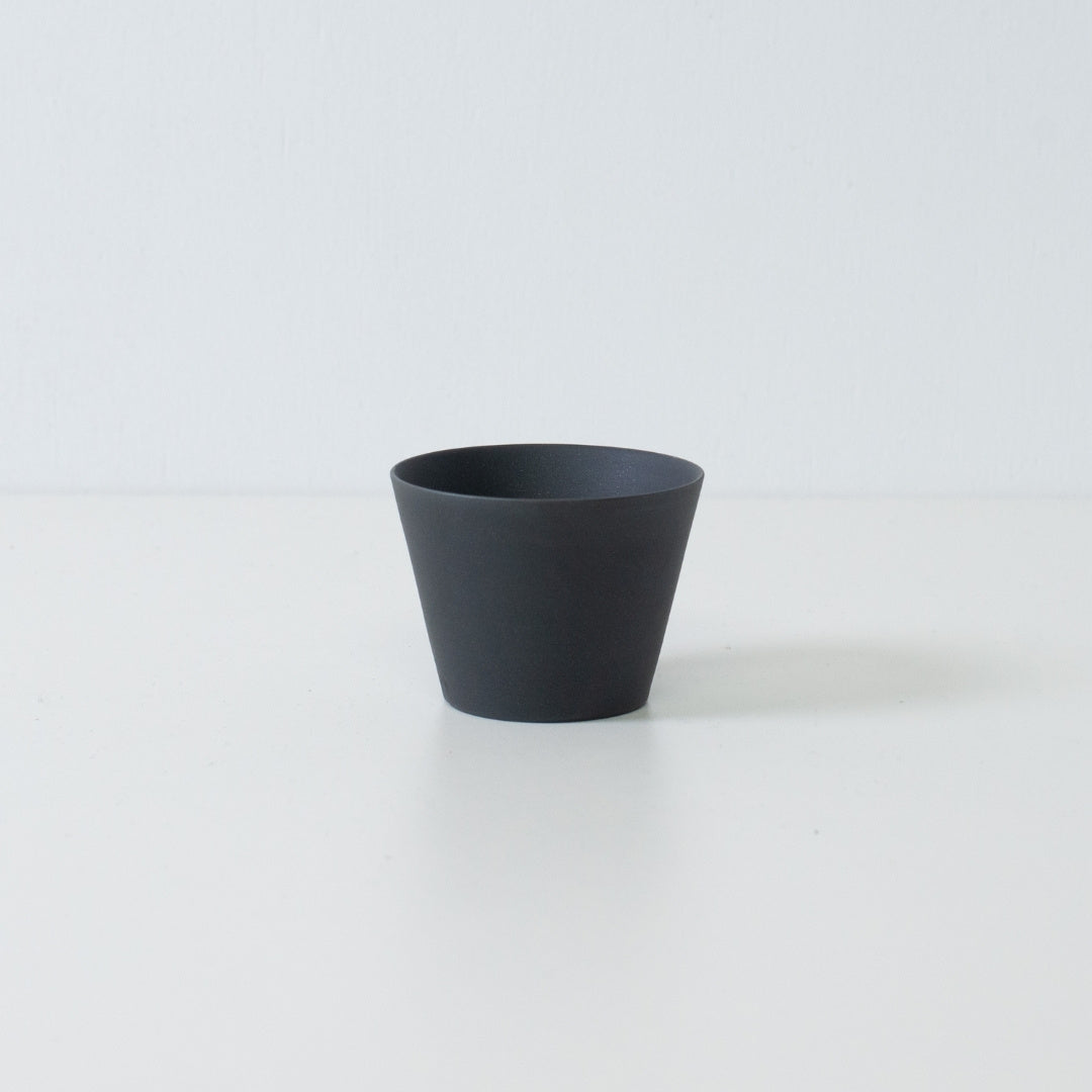 Single black japanese tea cup ensui with a matte unglazed texture and modern cone shape design