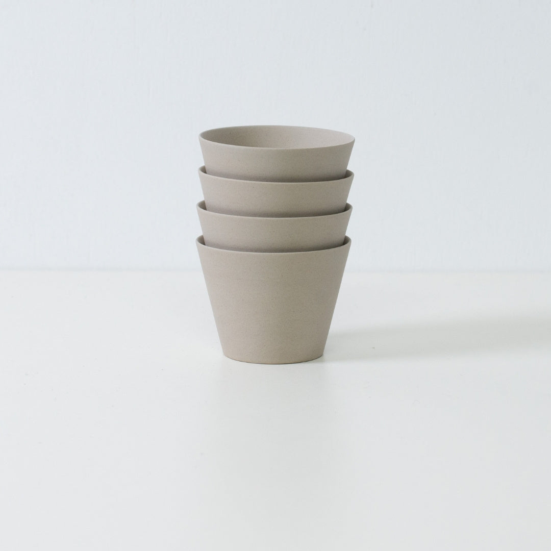 Stack of four ensui white japanese tea cups demonstrating compact storage and the matte stoneware texture of the set.