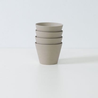 Stack of four ensui white japanese tea cups demonstrating compact storage and the matte stoneware texture of the set.