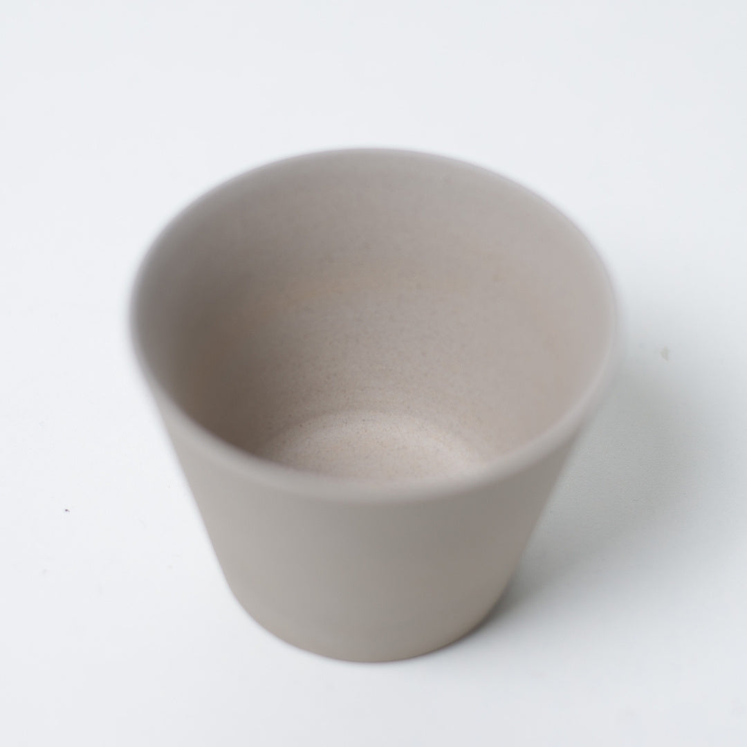 Close up look inside an unglazed white japanese tea cup highlighting the smooth clay texture of the ensui chawan.