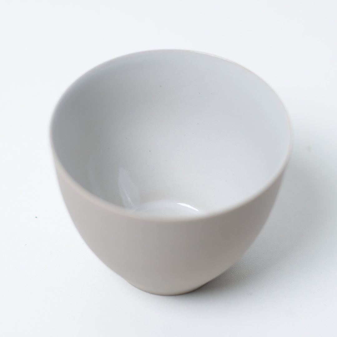 Close up looking inside a white japanese tea cup showing the smooth glossy interior glaze designed to enhance tea color