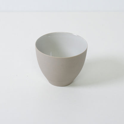 High angle shot of a white japanese tea cup highlighting the contrast between the unglazed exterior and glazed interior