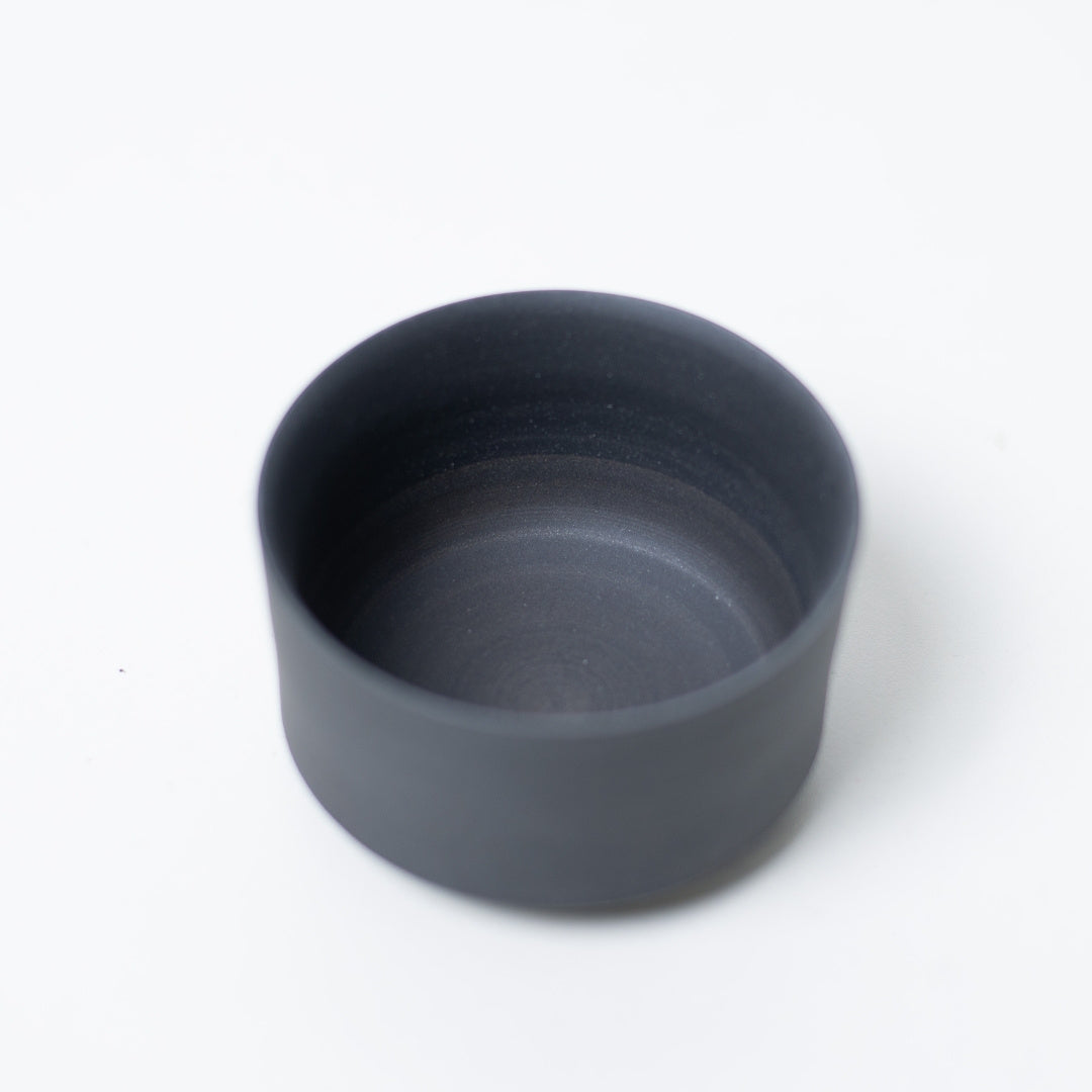 Interior view of a black japanese tea cup showing the unglazed texture that mellows tea flavor and prevents odors