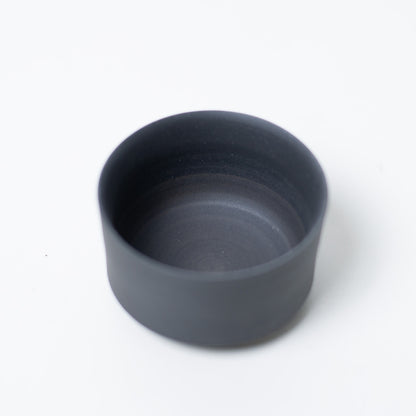 Interior view of a black japanese tea cup showing the unglazed texture that mellows tea flavor and prevents odors