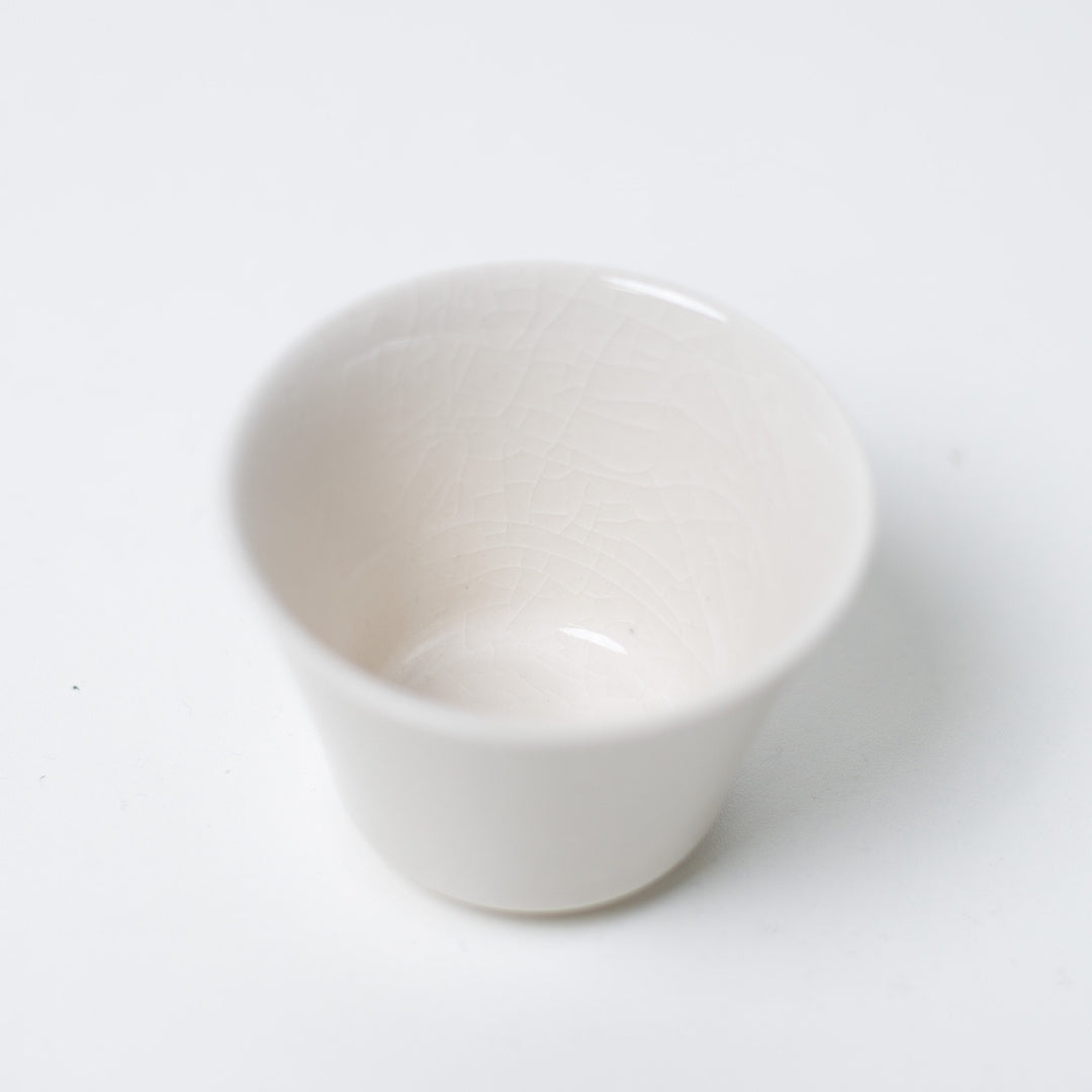 Interior view of a white kodai japanese tea cup highlighting the delicate crackle glaze pattern on the porcelain