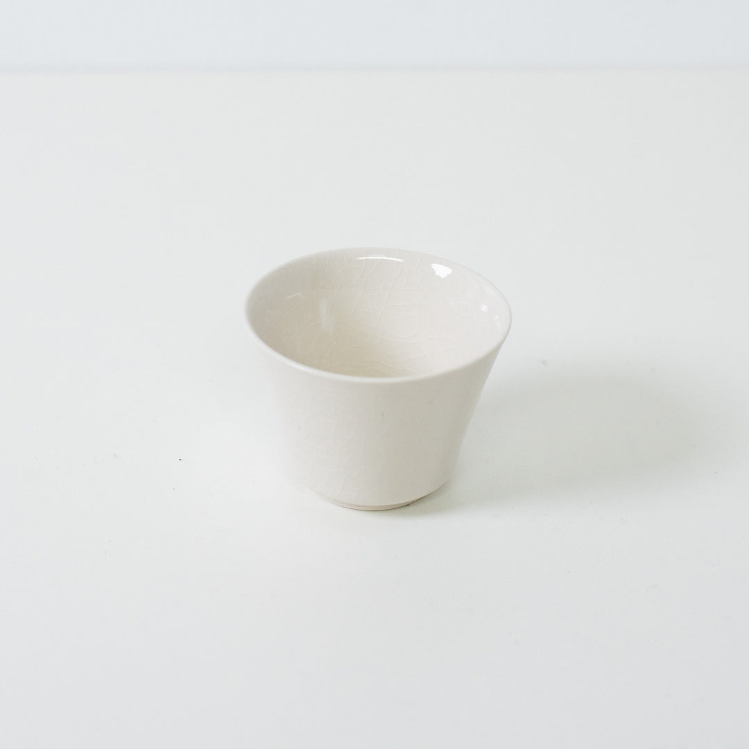 White kodai japanese tea cup featuring a traditional high footed base and glossy crackle glaze finish.