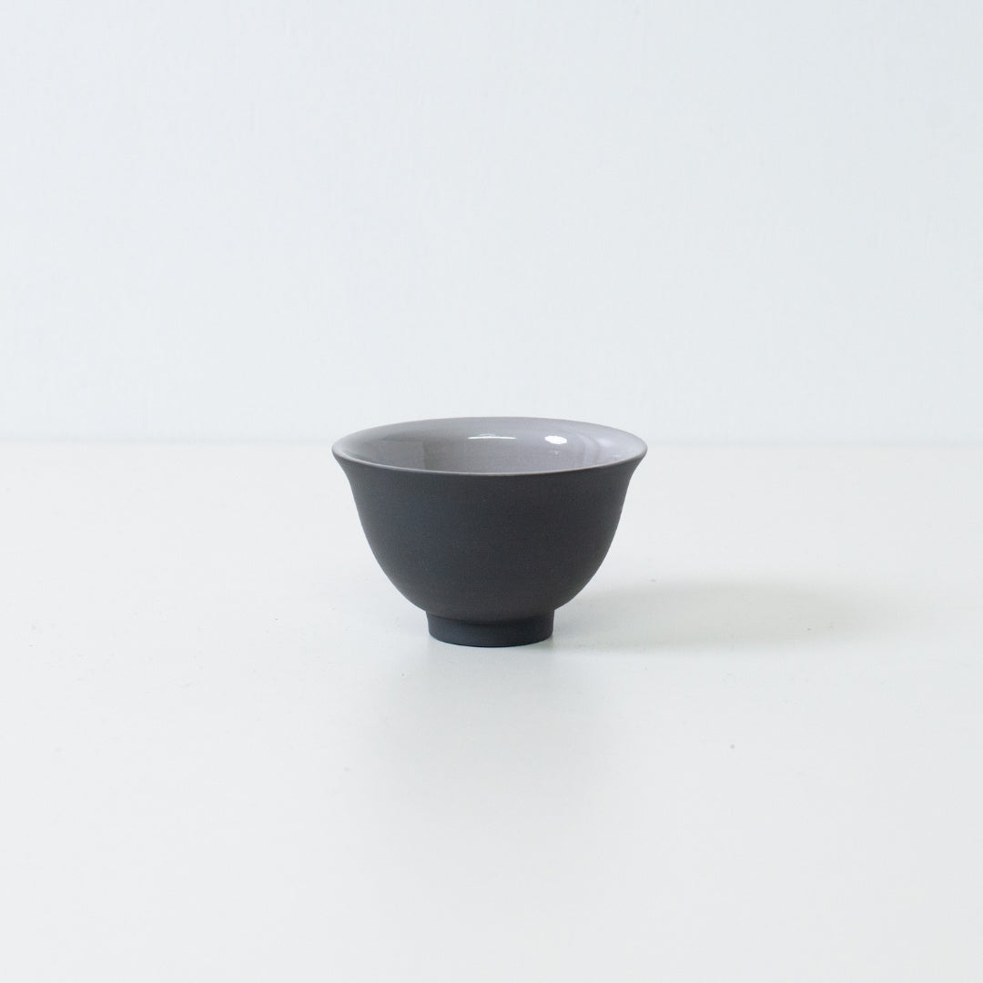 Single black kumidashi japanese tea cup with wide mouth silhouette standing on white background.
