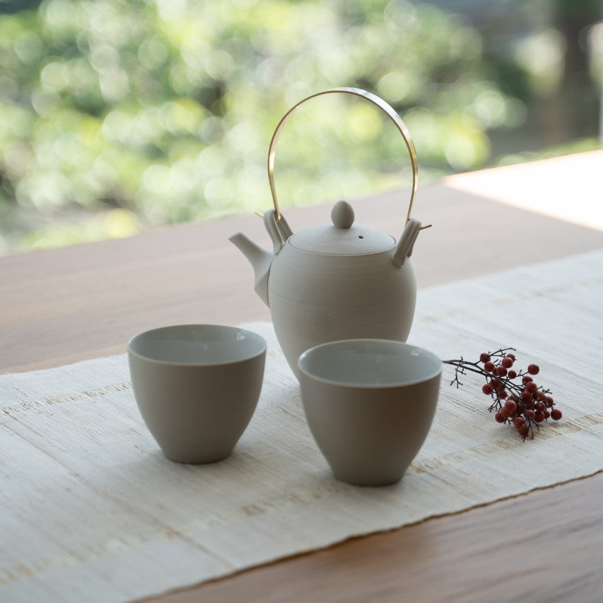 Hvid japansk tekande "Donguri" og japanske tekopper på et bord til wellness-søgende, der omfavner et moderne zen-ritual.