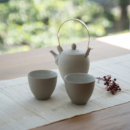 Hvid japansk tekande "Donguri" og japanske tekopper på et bord til wellness-søgende, der omfavner et moderne zen-ritual.