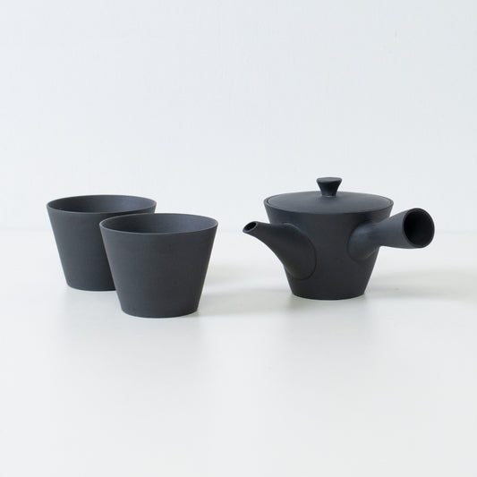 Japanese tea set featuring a black sencha kyusu teapot and two matte ensui chawan tea cups placed on a white table.