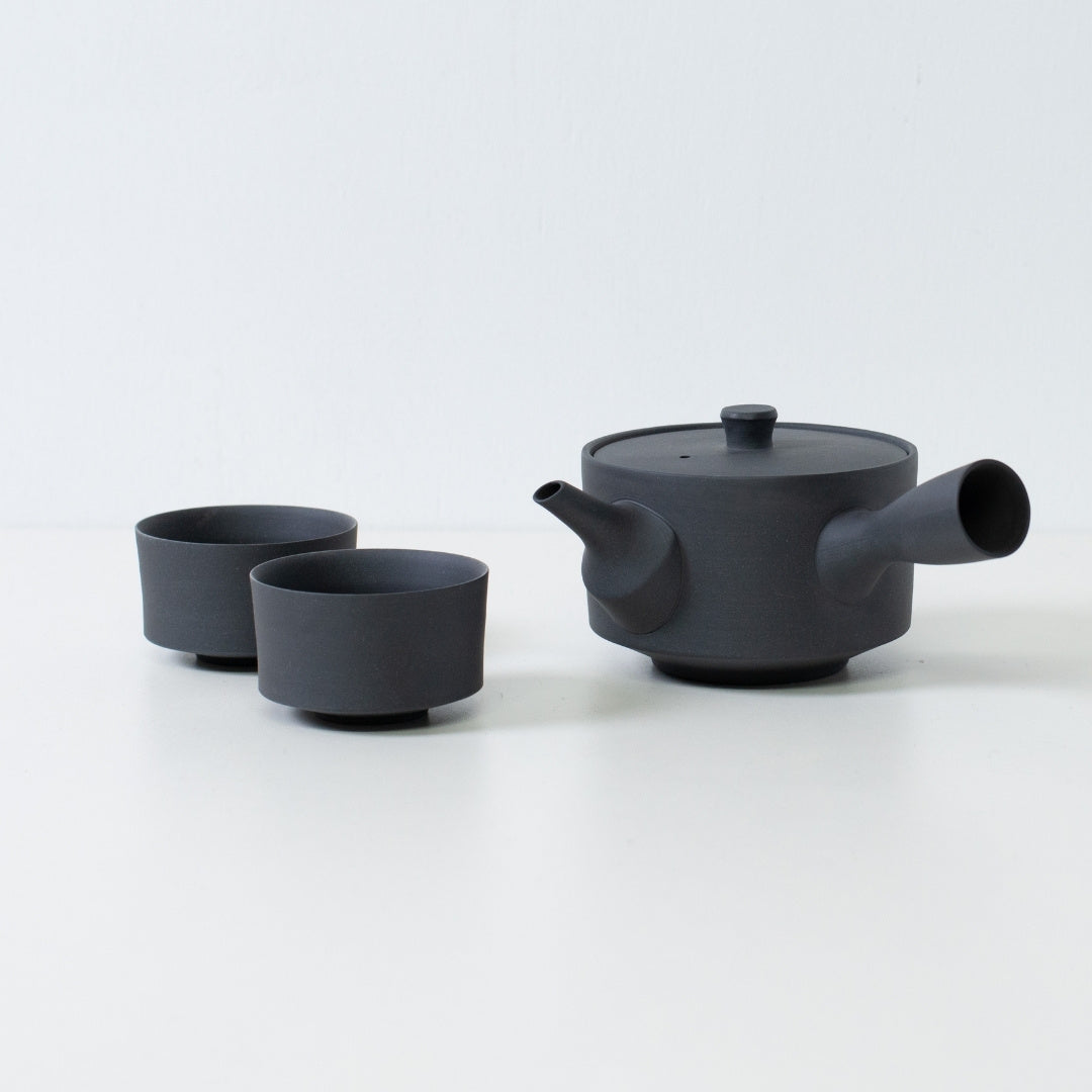"Service à thé japonais noir mat comprenant une théière sencha kyusu de 350cc et des tasses chawan cylindriques minimalistes sur une table blanche"