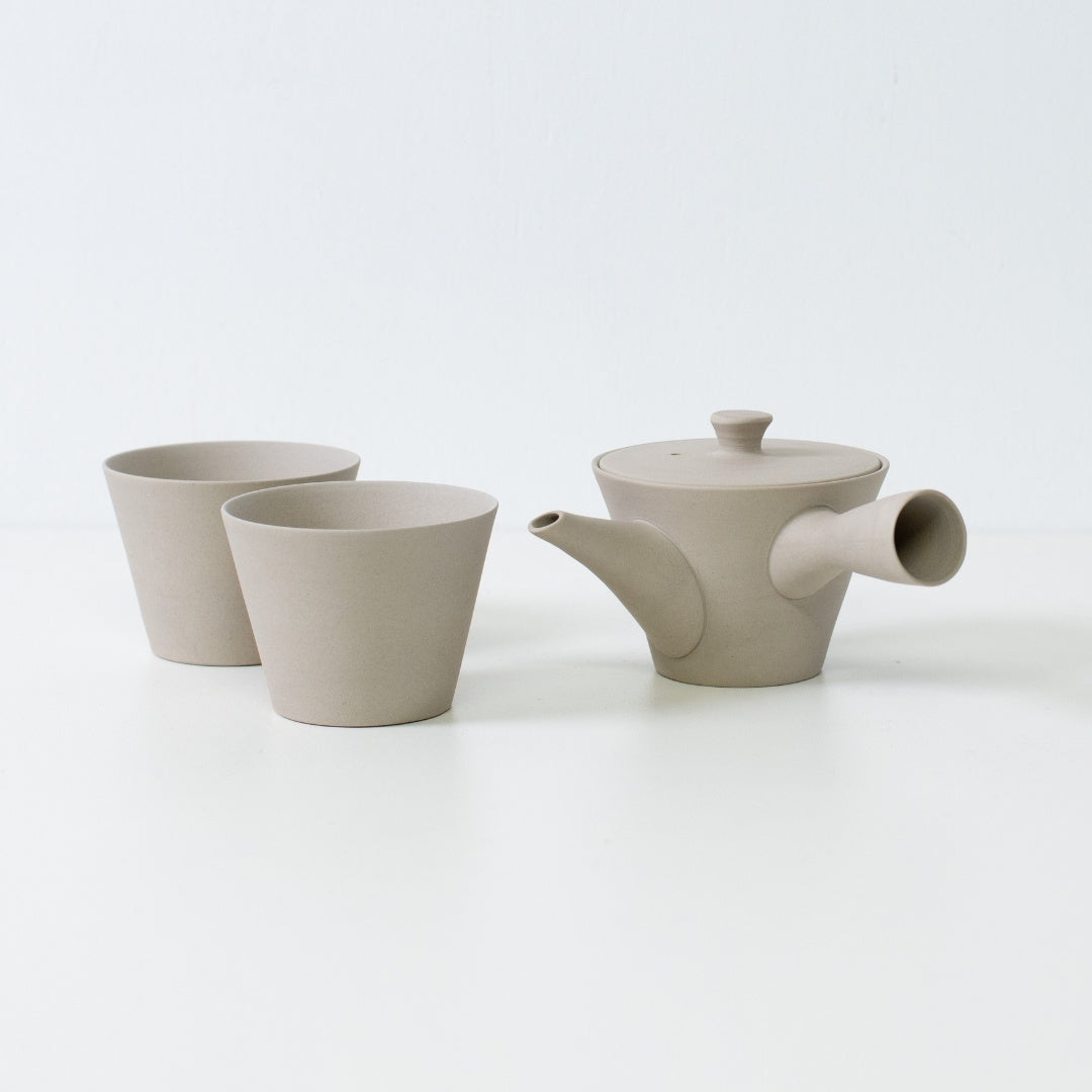 White unglazed japanese tea set featuring a sencha kyusu teapot and two matte cone shaped ensui cups for mindful brewing.