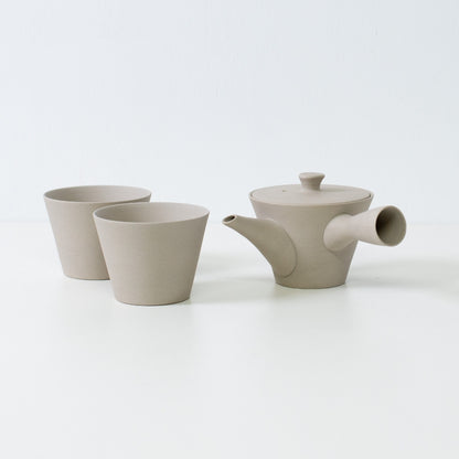 White unglazed japanese tea set featuring a sencha kyusu teapot and two matte cone shaped ensui cups for mindful brewing.