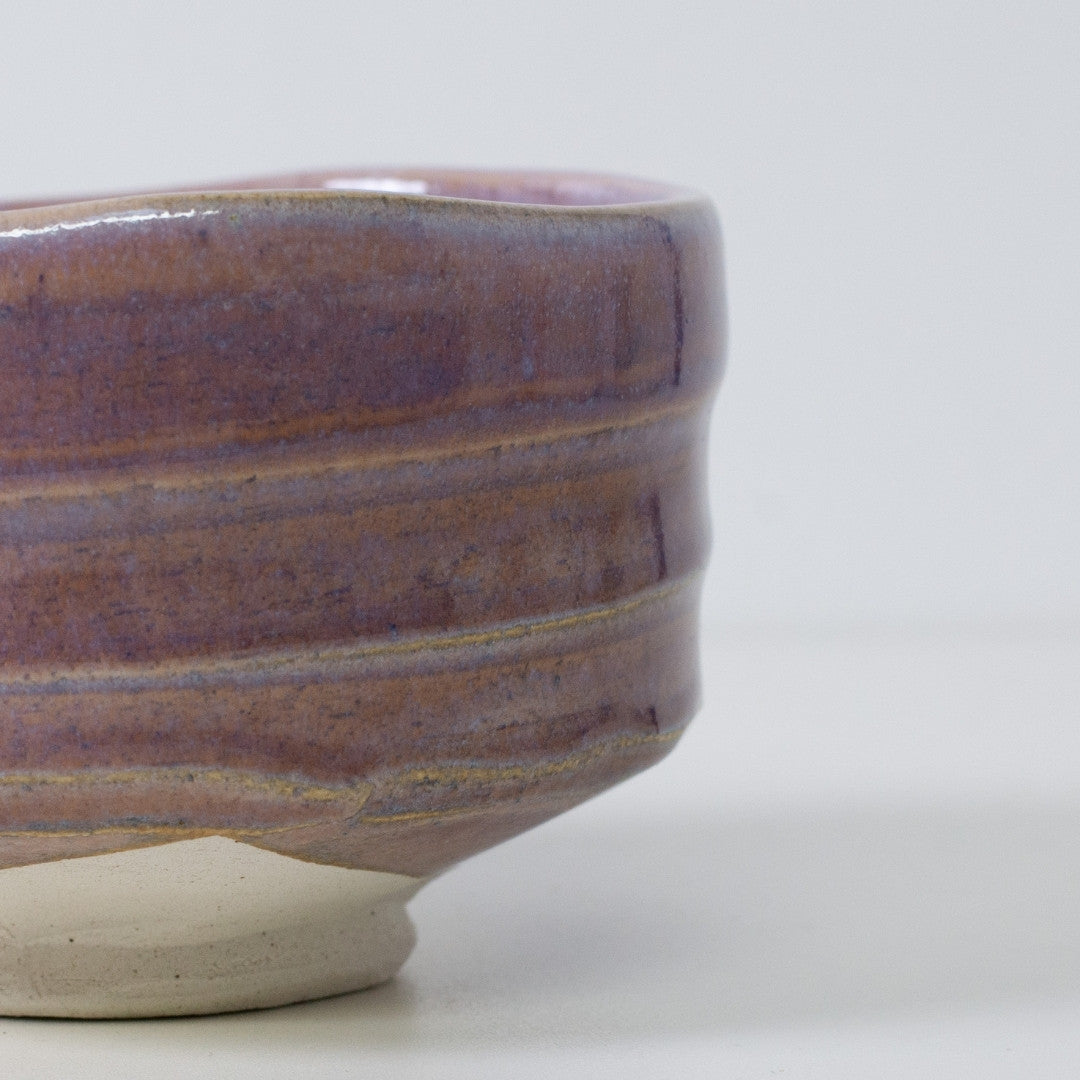 Close-up of "Pale Violet" matcha bowl showing the translucency of the glaze over the brown Shino clay base.