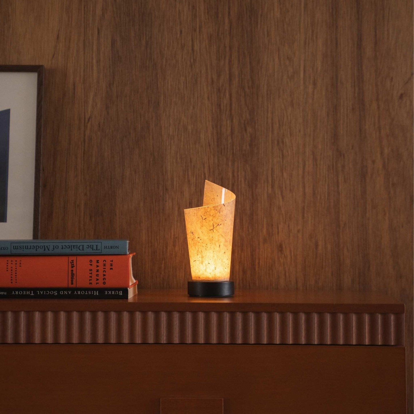Lit Japanese paper table lamp "Maki" Cedar Bark casting soft upward light as an ambient lamp on a mid-century modern console table.