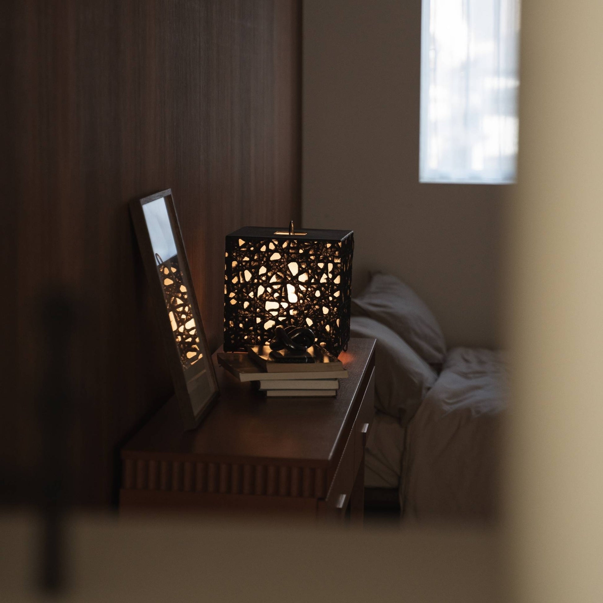 Illuminated cube Japanese paper lamp Me Look 03 acting as an accent light on a wooden console table with decor.