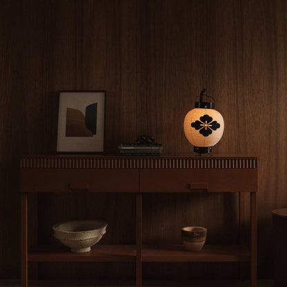 Lit small Japanese paper lantern standing on a mid century modern console table in a dim living room