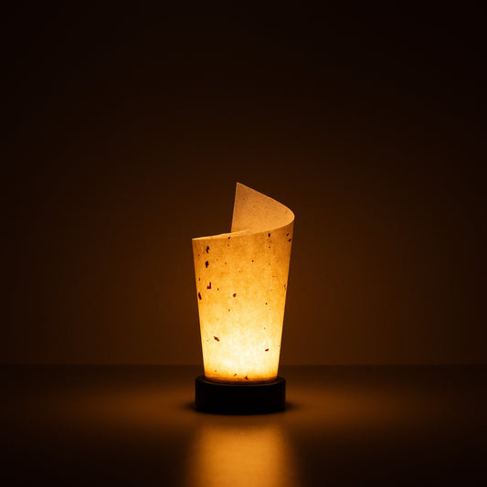 Japanese Paper Table Lamp "Maki", natural, Mino Washi paper - lit paper lamp casting a warm glow with visible rustic flecks.