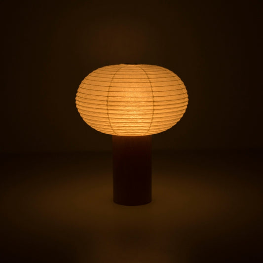 Portable paper lamp "TORCHIN OVAL" emitting a warm glow, handcrafted in Yame, Fukuoka, Japan, known for its traditional Yame lanterns.