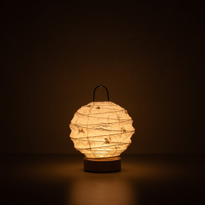 Japanese Paper Table Lamp "Yuhi" Rabbit, white, Mino Washi paper - lit round paper lamp casting a warm glow in a dark room.