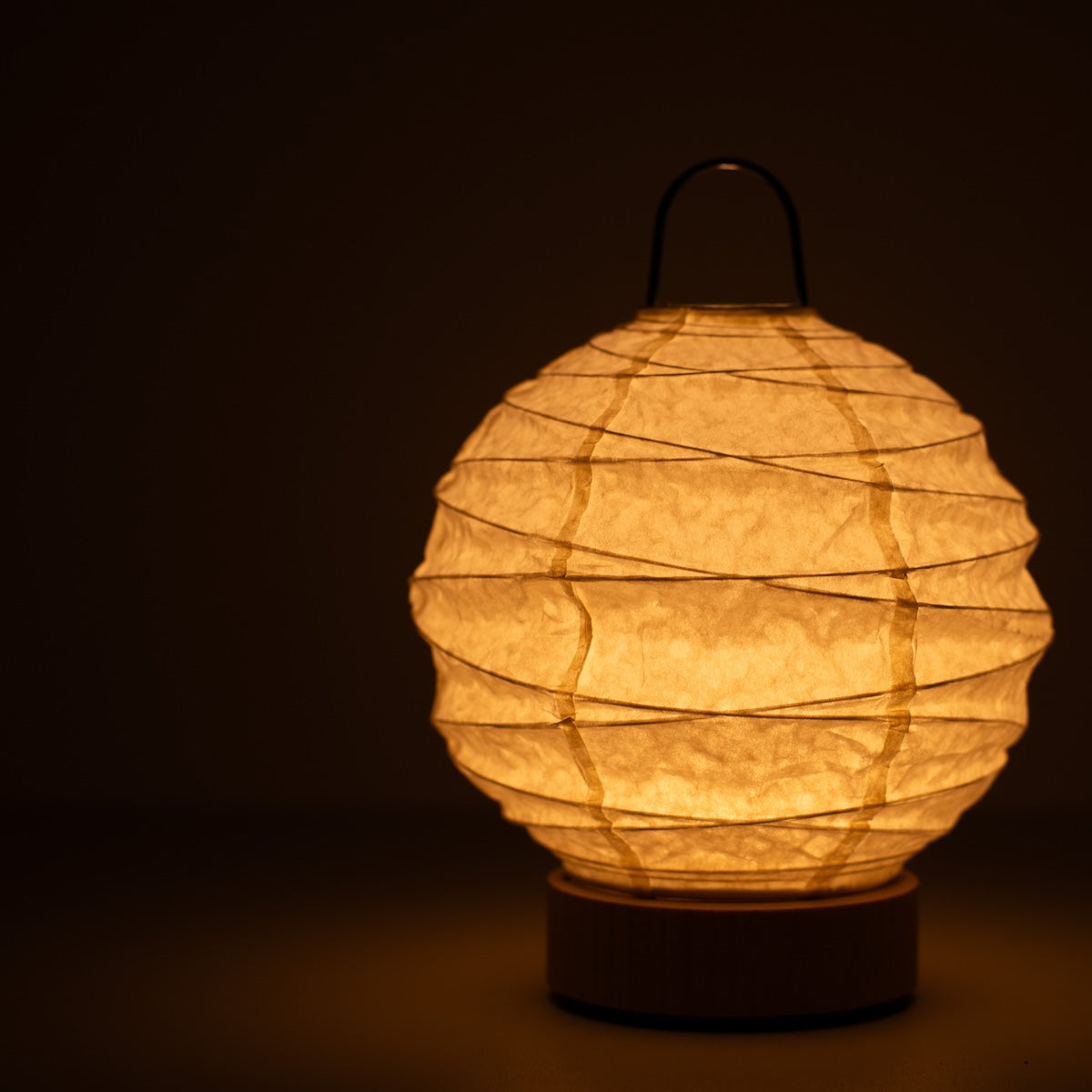 Japanese Paper Table Lamp "Yuhi", white, Mino Washi paper - close-up of illuminated wabi sabi table lamp showing texture.