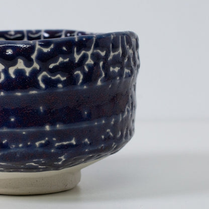 Detail of Kairagi (crawled glaze) texture on a midnight blue matcha chawan bowl, highlighting the unique wabi sabi cracks and ceramic craftsmanship.