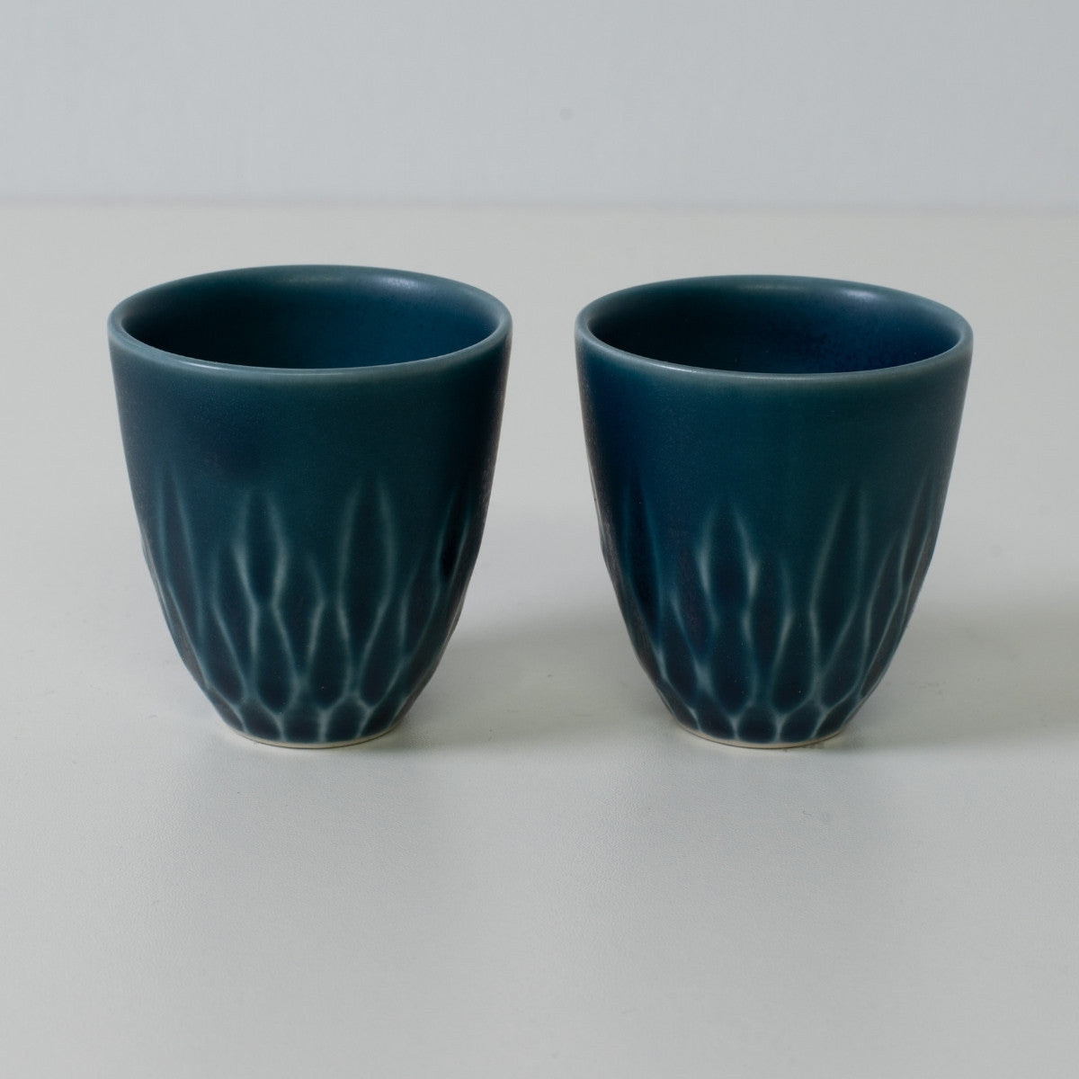 Matte lapis sake cups, blue, porcelain - Two matte blue Japanese sake cups with carved base details