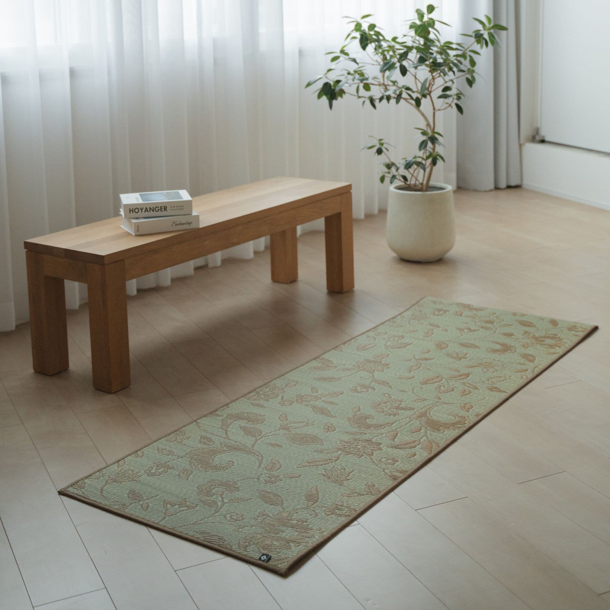 Japanese Tatami Yoga Mattress "Sarasa" Beige with botanical pattern placed on a wooden floor in a minimalist living room for home practice.