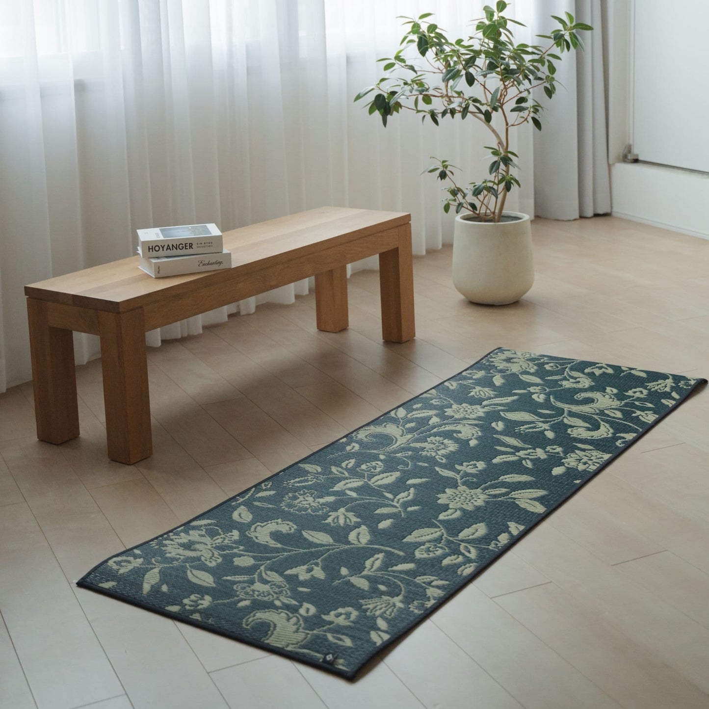 Japanese Tatami Yoga Mattress "Sarasa" Navy on a wooden floor in a minimalist living room for home yoga or meditation.