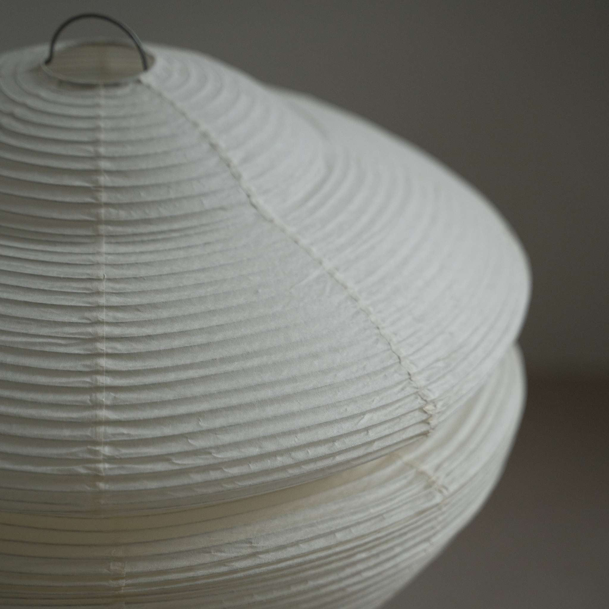 Close up detail showing the translucent texture and ribbed design of the Harusame Mino Washi paper on the Gemini 01 lamp shade.