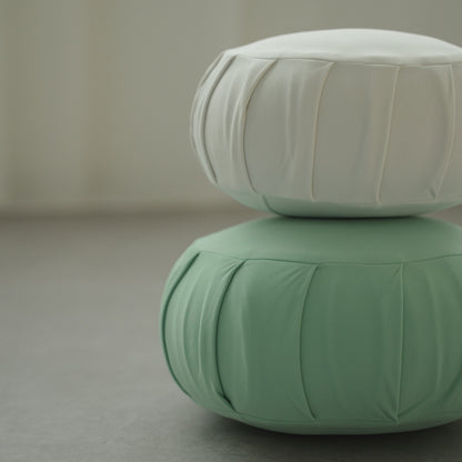 Moonlight white and mint green Japanese meditation cushion zafu, stacked in a modern room ready for a family zen routine.