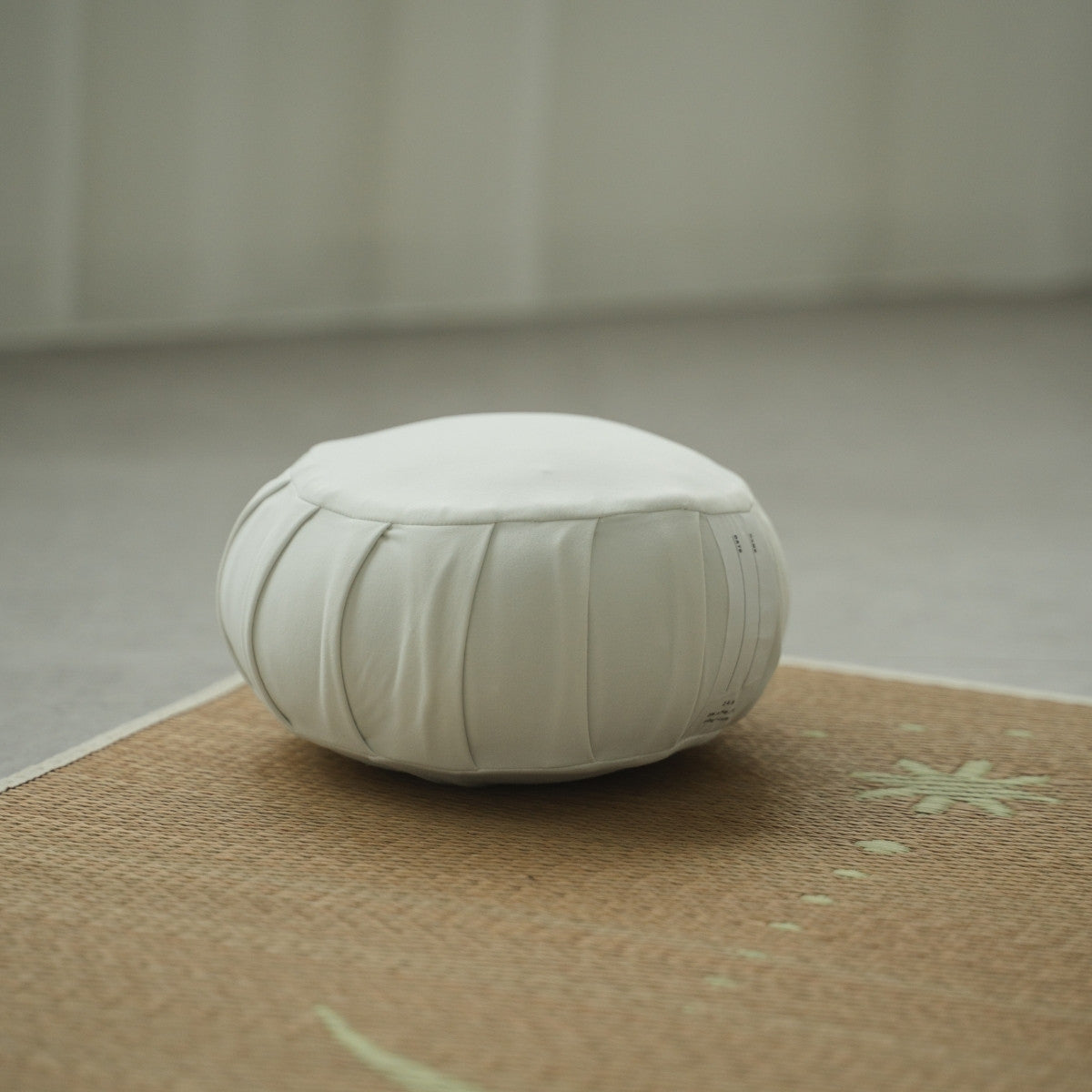 Moonlight white Japanese meditation cushion zafu, on a tatami mat in a bright room for a morning zen routine.