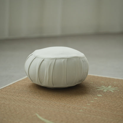 Moonlight white Japanese meditation cushion zafu, on a tatami mat in a bright room for a morning zen routine.