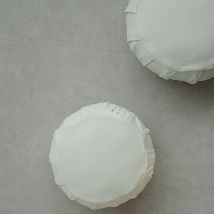 Two moonlight white Japanese meditation cushions (zafu) on a modern grey floor, ready for a family mindfulness routine.
