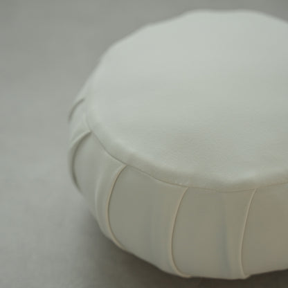 Close-up of a moonlight white Japanese meditation cushion (zafu) showing fabric details on a modern floor for home yoga.