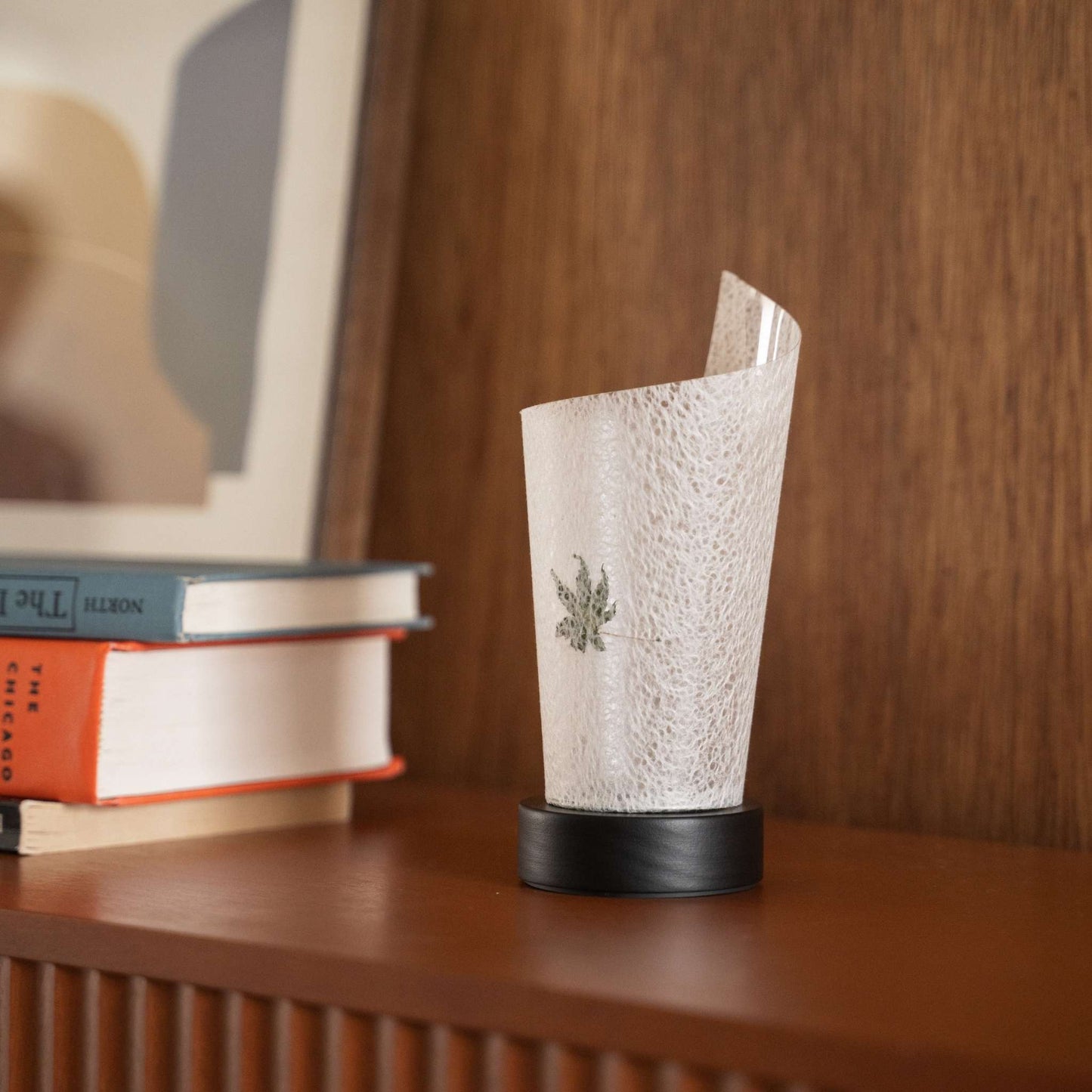Close-up of an unlit Japanese paper table lamp "Maki" Momiji Leaf highlighting its natural flecks and wabi sabi aesthetic on a console.
